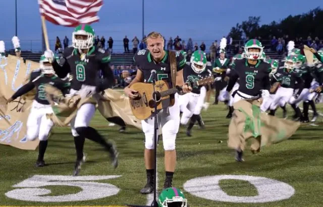 No one was willing to sing the national anthem, so one high schooler took off his helmet and grabbed a guitar.